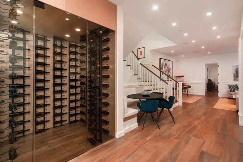Glass-walled wine cellar with floor-to-ceiling metal racking in a finished basement